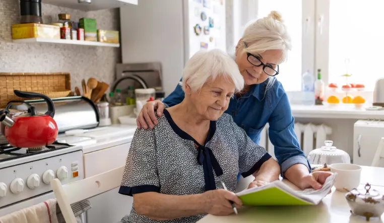 daughter and mom looking over paperwork in a folder