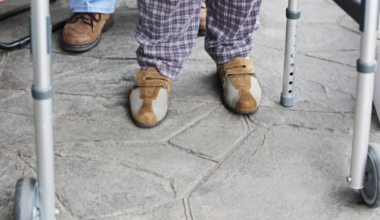 feet on the ground showing shoes and walker