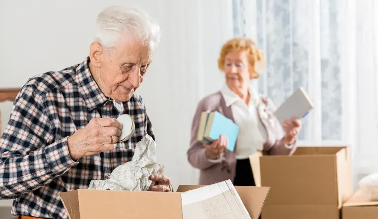 older people looking through moving boxes