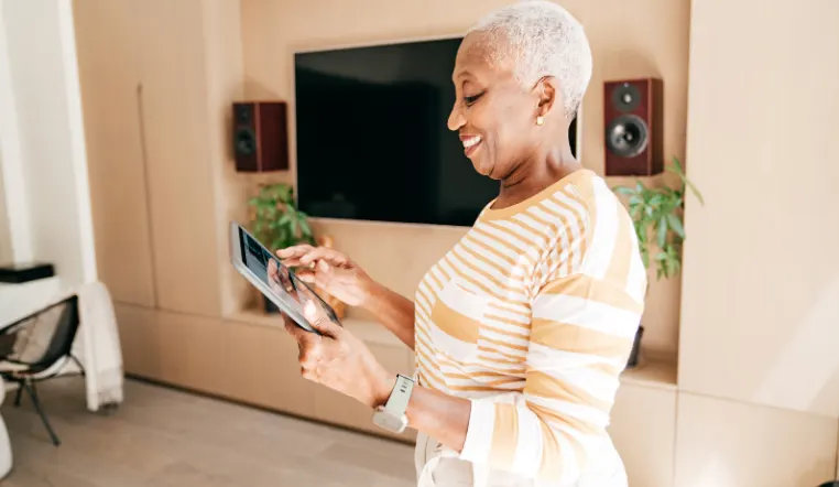 older lady looking at tablet smiling