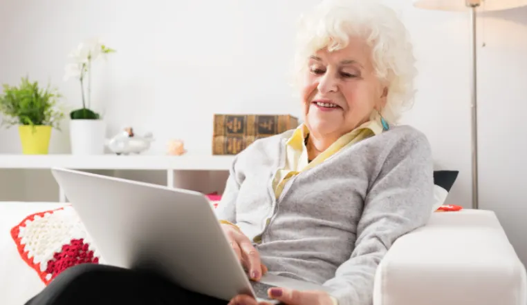 older lady smiling while on laptop