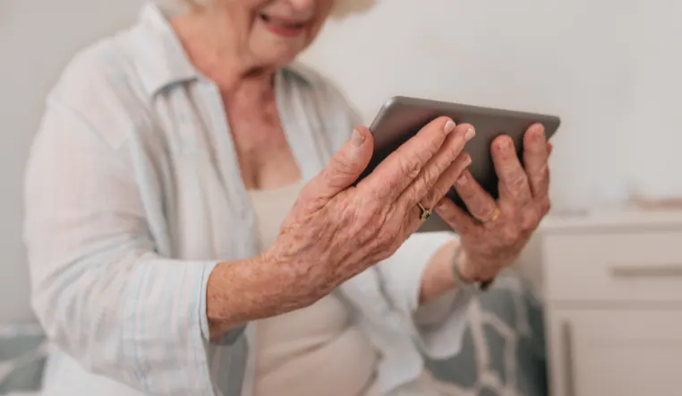 senior holding a tablet