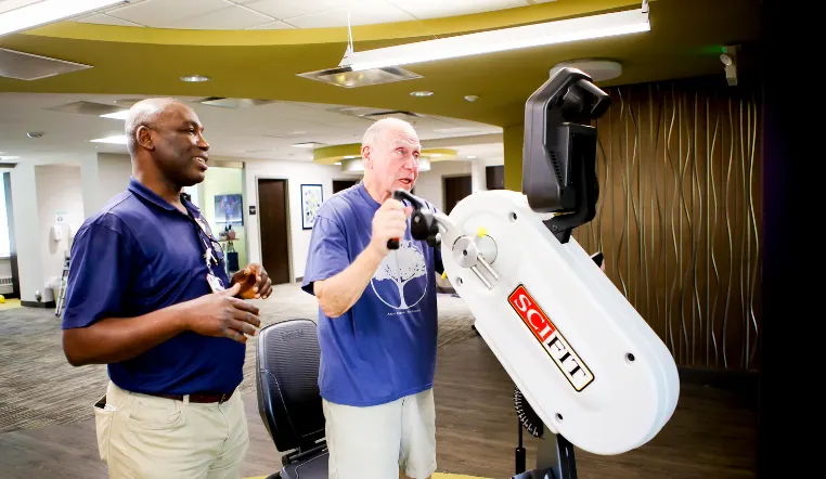 older man using equipment for rehabilitation