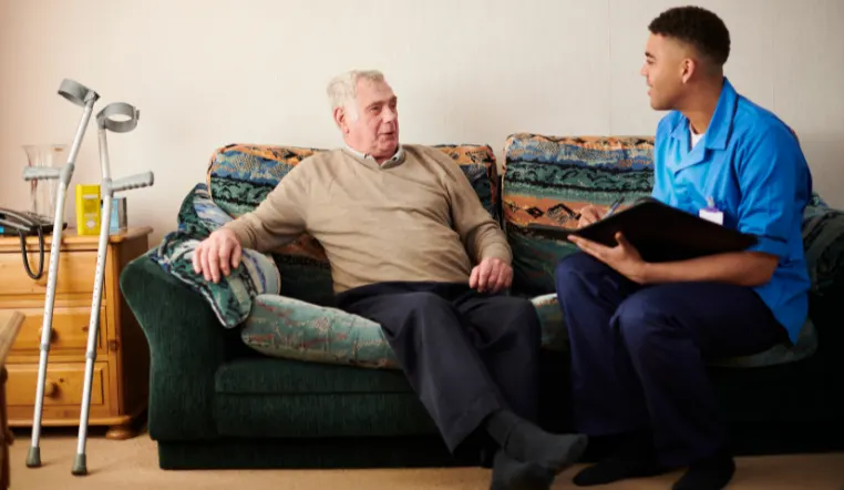 doctor and senior talking on a couch