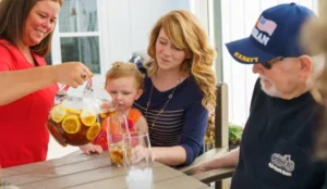family sitting outside getting sweet tea poured for them