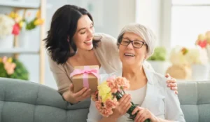 daughter gifting flowers and a box for mothers day