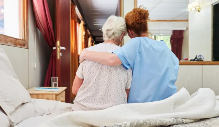 senior and nurse leaning on each other