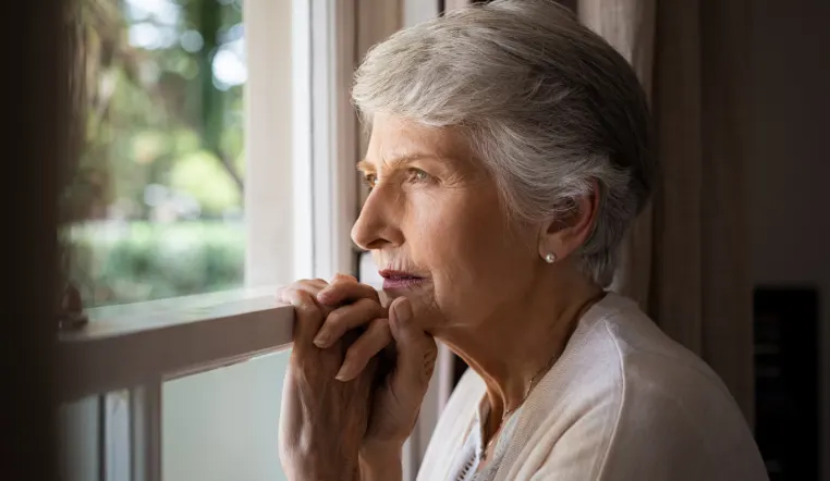 senior woman looking out a window