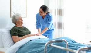 senior lady in hospital bed with nurse by side