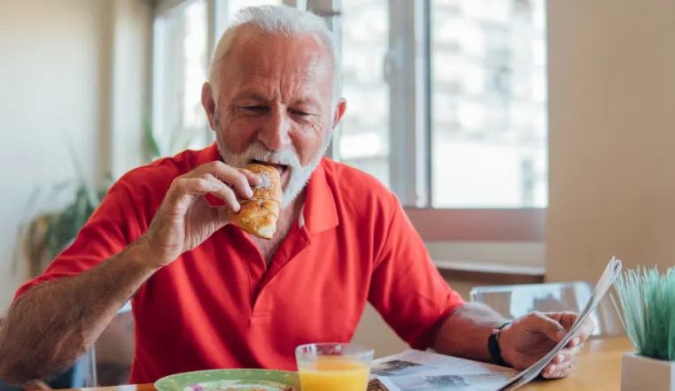 senior eating a pastry