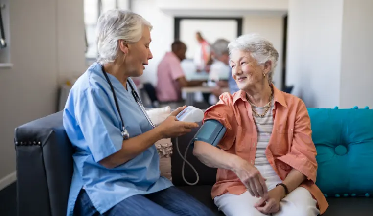 nurse taking blood pressure of senior