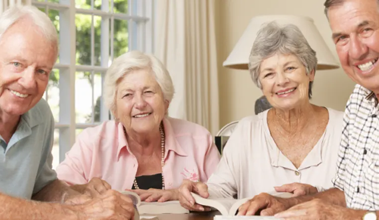 seniors reading books smiling