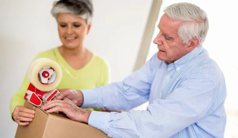 senior man taping a moving box