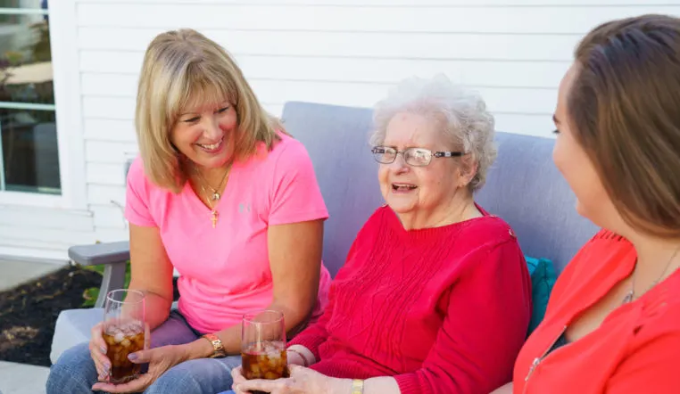 family smiling and sitting on chair drinking tea