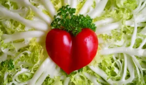 Heart-shaped tomato on top of lettuce signifying heart health