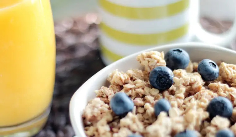 Bowl of oatmeal with blueberries and a glass of orange juice