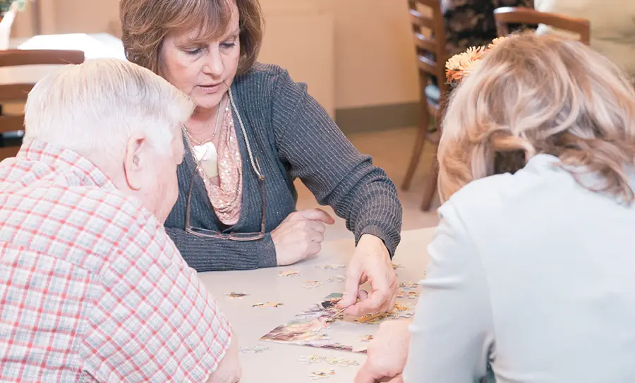 Visitor doing a puzzle with residents