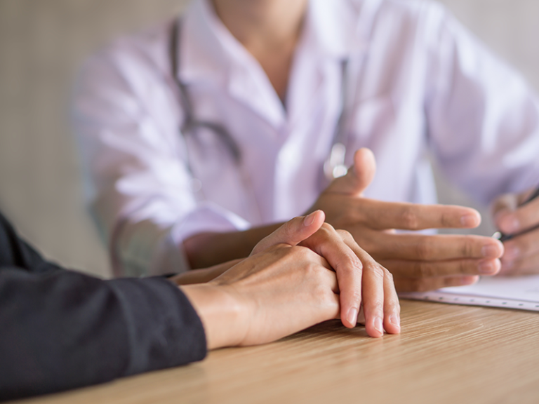 Doctor talks to patient and hands are shown