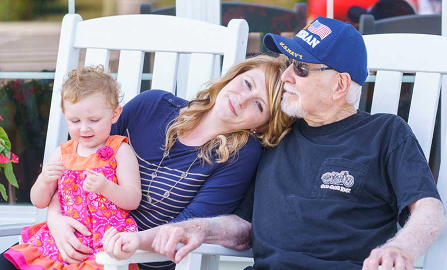 Adult daughter rests her head on her senior father's shoulder