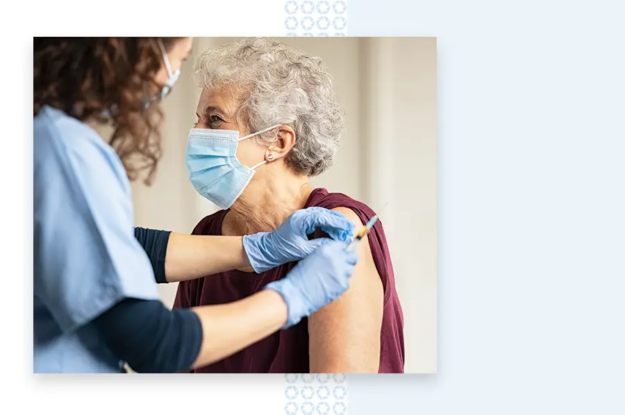 Nurse giving a patient a vaccine in the arm while both wear masks