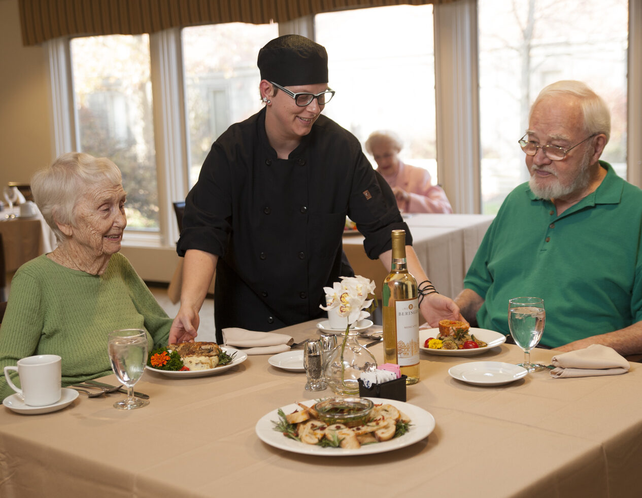 Chef bringing out dishes to senior residents