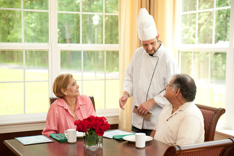 Chef speaks to couple in dining room