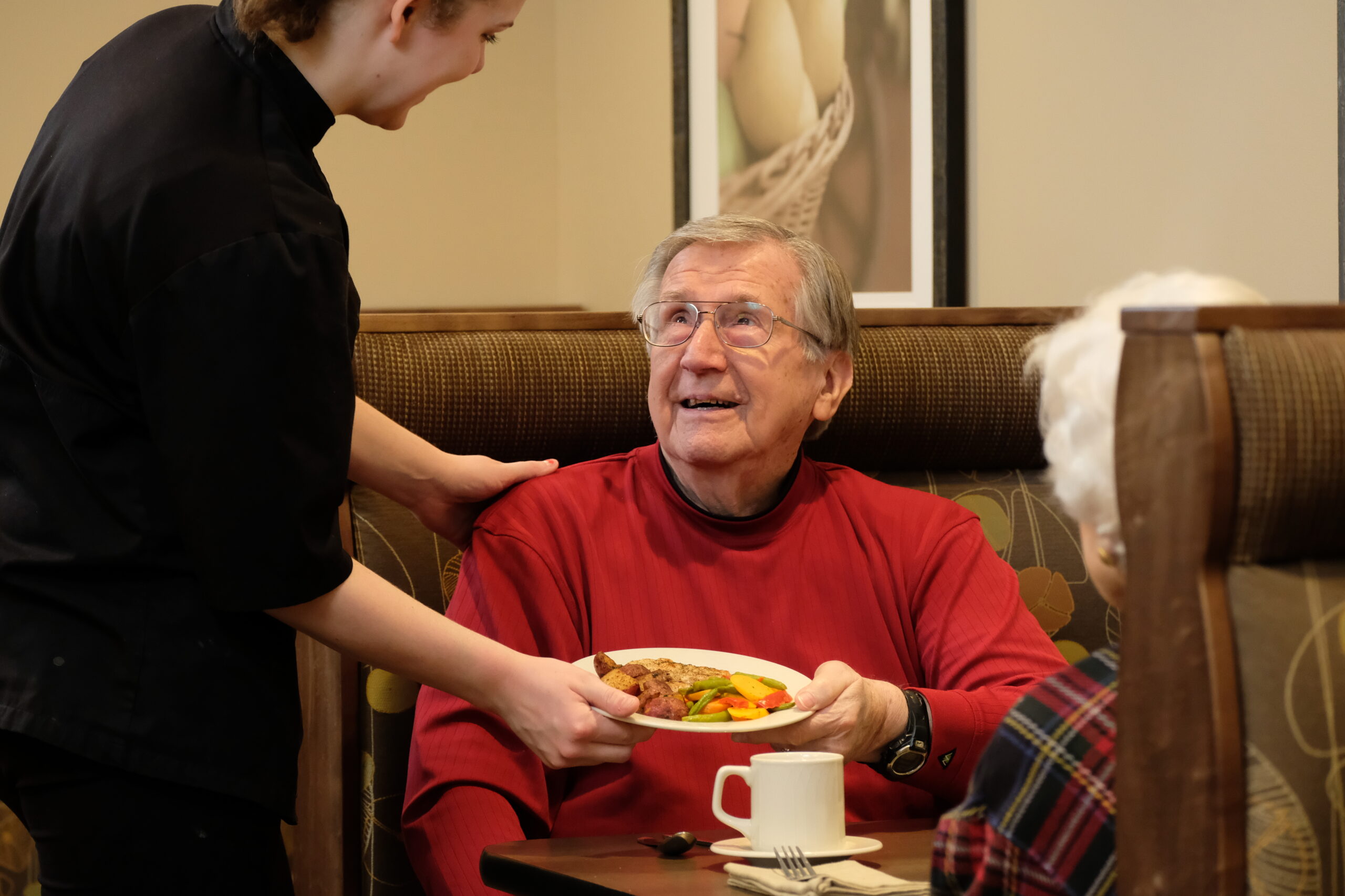 Chef delivers plate of food to residents