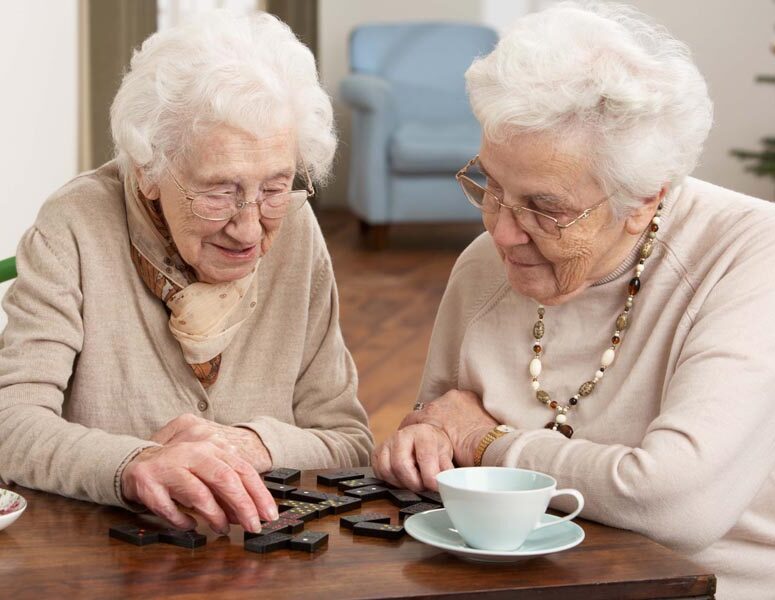 Two Senior Women Playing Dominoes