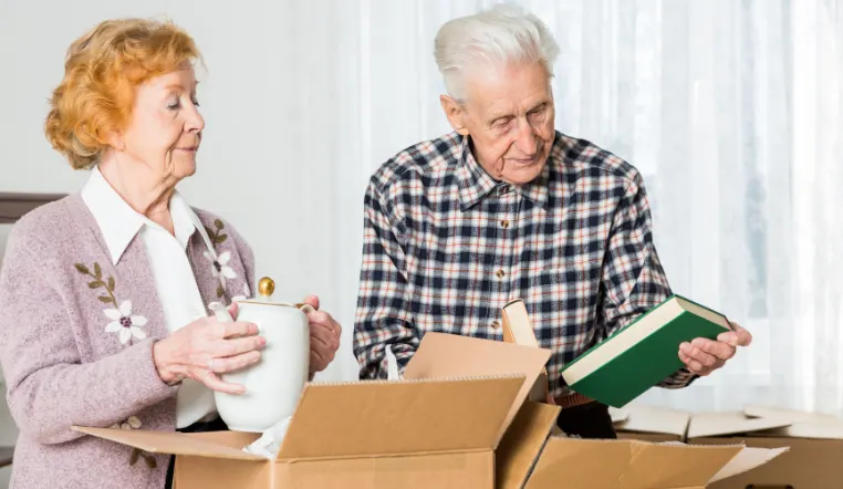 seniors looking at items from box