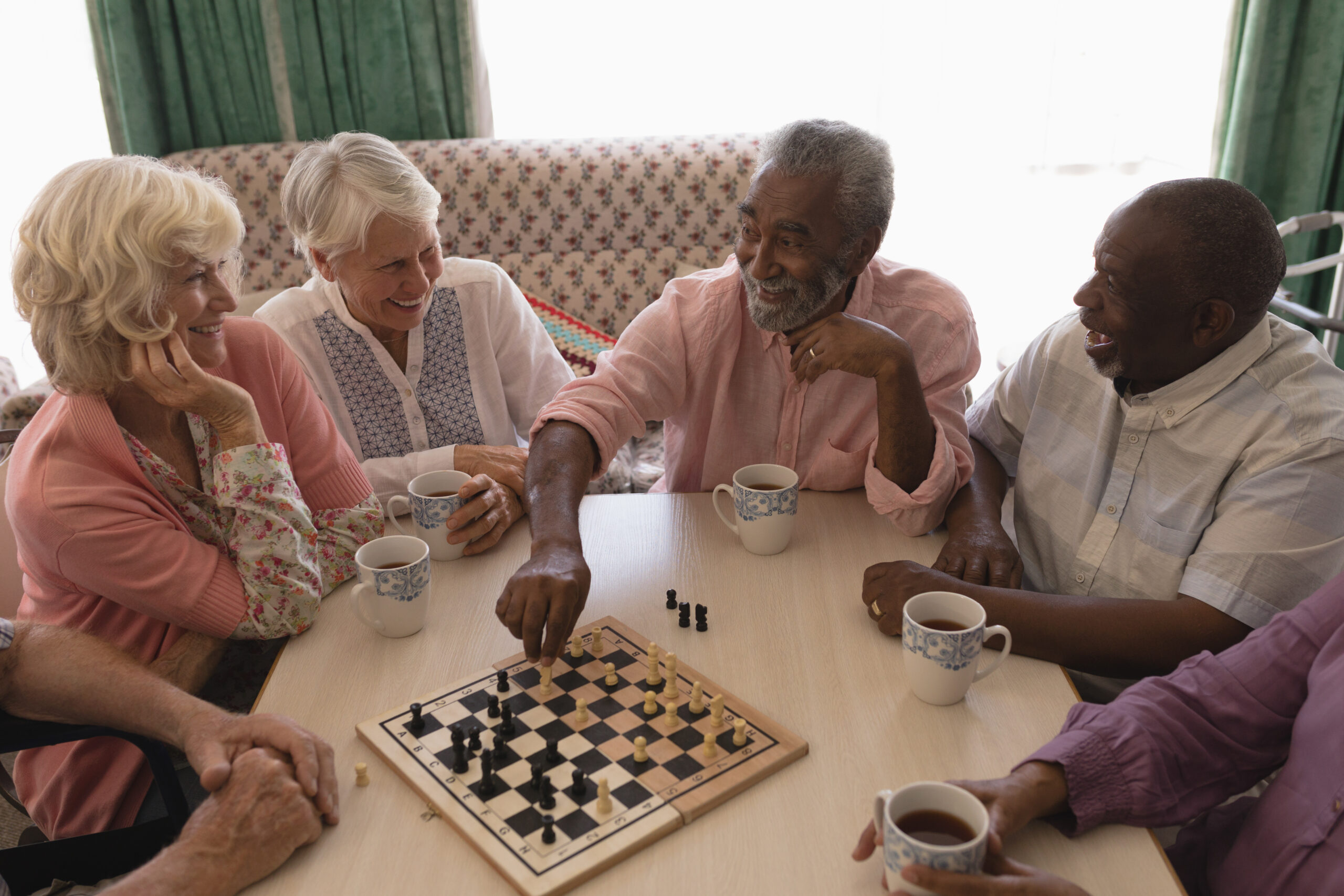 Group of senior adults playing chess around a table