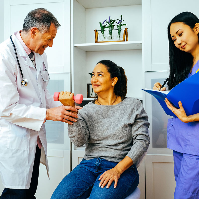 rehabilitation doctor physiotherapist physician and nurse practitioner helping patient lift dumbbell with one hand. Healthcare industry rehabilitation doctor and therapist working with patient