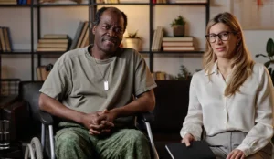 Veteran in wheelchair next to professional woman holding a notebook