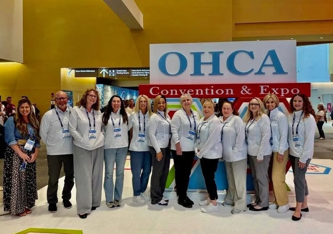 image Group standing in front of the sign at the OHCS convention and expo